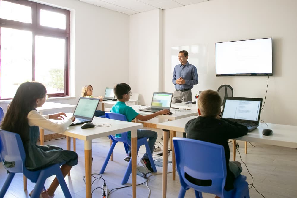 Students collaborating around digital devices in a modern, technology-enabled classroom
